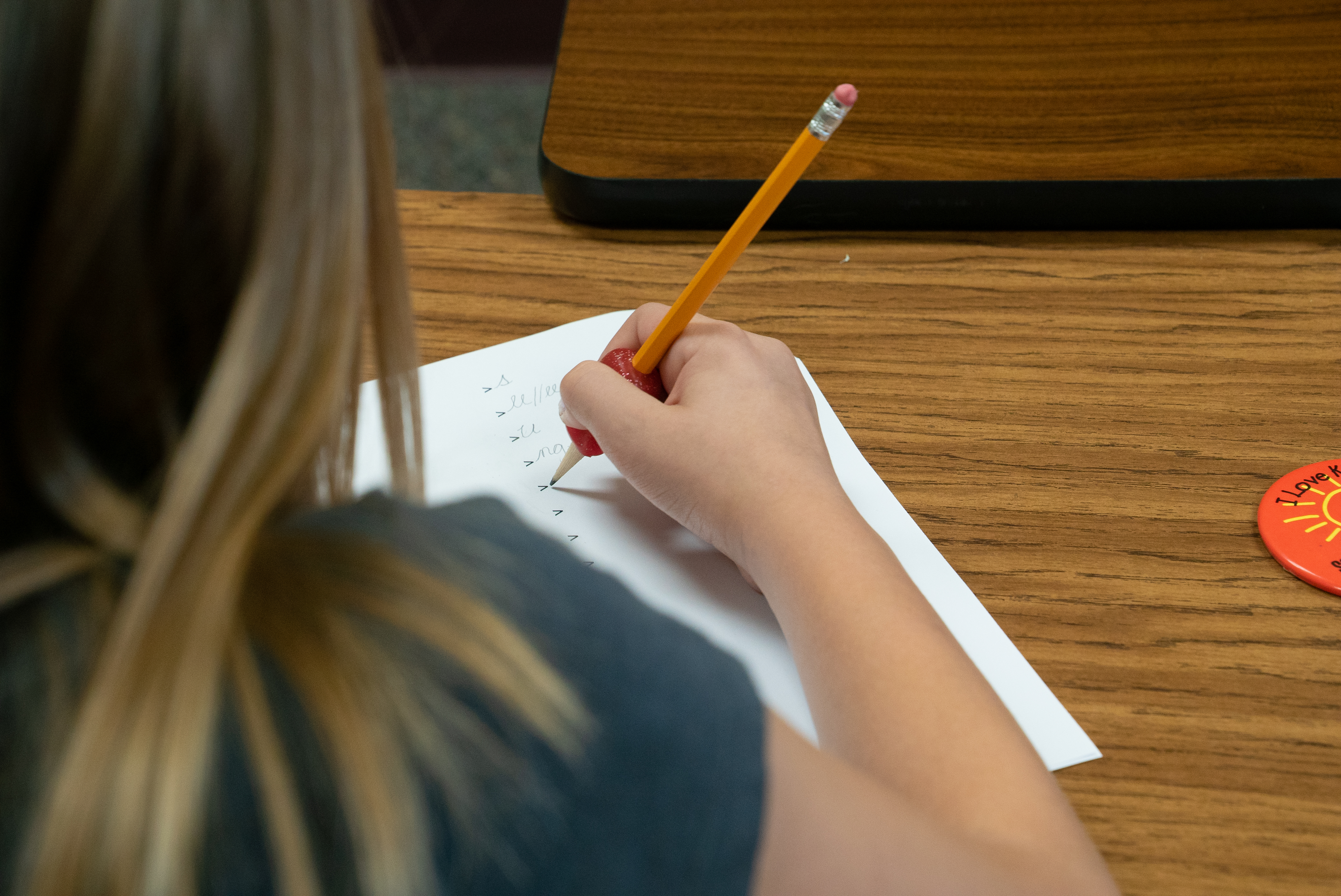 Girl writing in class undergoing language training for students with dyslexia